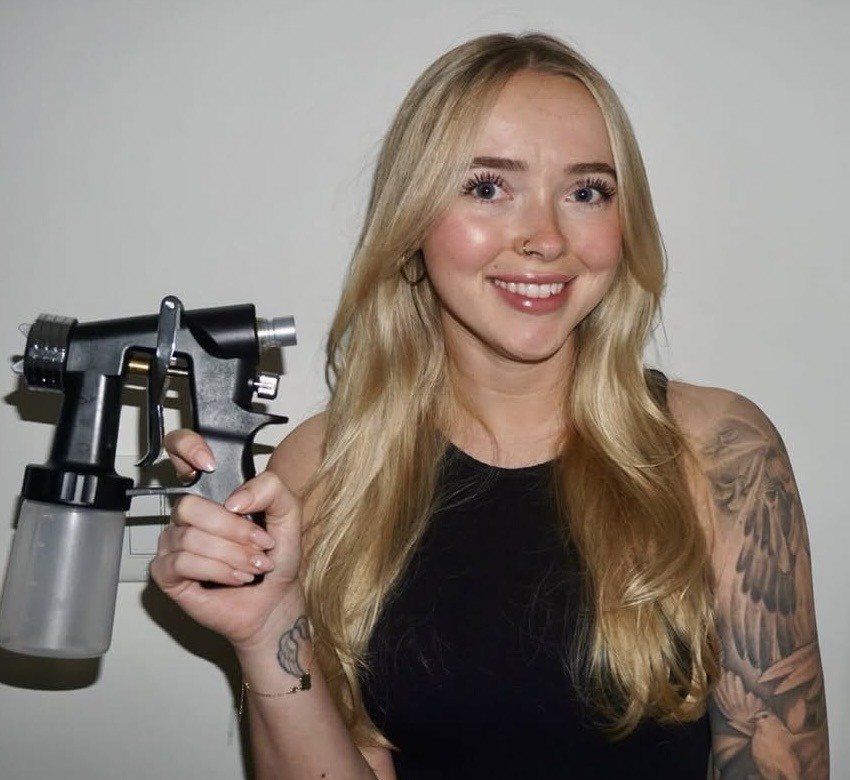Savanna, owner of Bronzed Behaviour, holding her spray tan gun